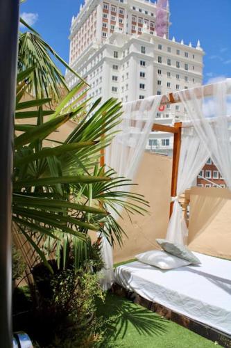 a bedroom with a bed and a palm tree in a city at Gran Vía-Plaza España 2 habitaciones in Madrid
