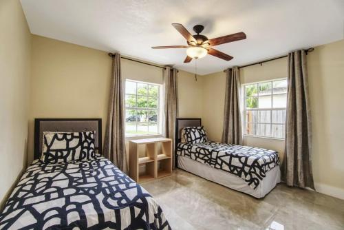 a bedroom with two beds and a ceiling fan at Relaxing 3 Bedroom House-Close to Beaches and Airport! in Fort Lauderdale