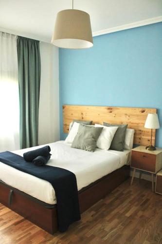a bedroom with a large bed with a blue wall at Gran Vía-Plaza España 2 habitaciones in Madrid