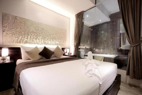 een slaapkamer met een groot wit bed en een bad bij OSGN Crystal Blue Hotel in Phnom Penh