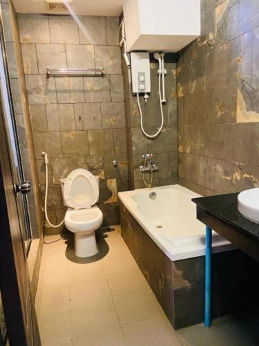 een badkamer met een toilet, een bad en een wastafel bij OSGN Crystal Blue Hotel in Phnom Penh