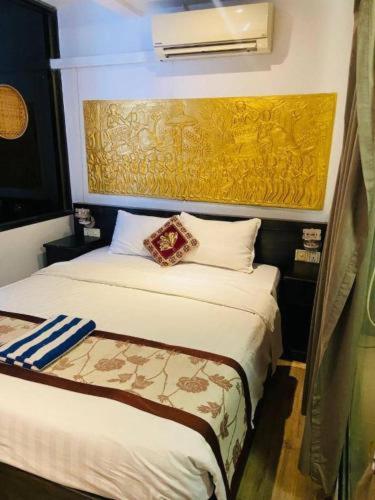 een slaapkamer met 2 bedden en een gele muur bij OSGN Crystal Blue Hotel in Phnom Penh