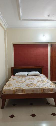 um quarto com uma cama grande e uma cabeceira vermelha em Prakruthi home 2 em Mangalore