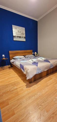 ein Schlafzimmer mit einem großen Bett mit blauer Wand in der Unterkunft Closer "Egnatia Apartment 4" in Thessaloniki