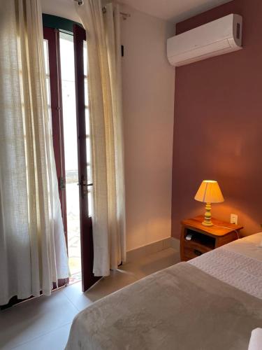 a bedroom with a bed and a lamp on a table at Pouso da Rita - Tiradentes in Tiradentes