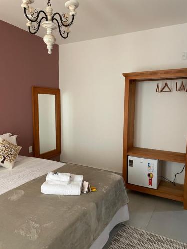 a bedroom with a bed with towels on it at Pouso da Rita - Tiradentes in Tiradentes
