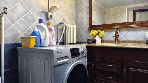 a washing machine in a kitchen with a sink at Chaoyang Joy City Hardcover Apartment in Beijing