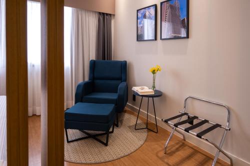 a room with a blue chair and a table at eSuítes Congonhas by Atlantica in Sao Paulo