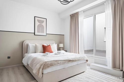 a white bedroom with a white bed and a window at Silkhaus High Floor 1BDR in Iconic DIFC Tower in Dubai