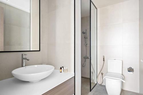 a white bathroom with a sink and a toilet at Silkhaus High Floor 1BDR in Iconic DIFC Tower in Dubai
