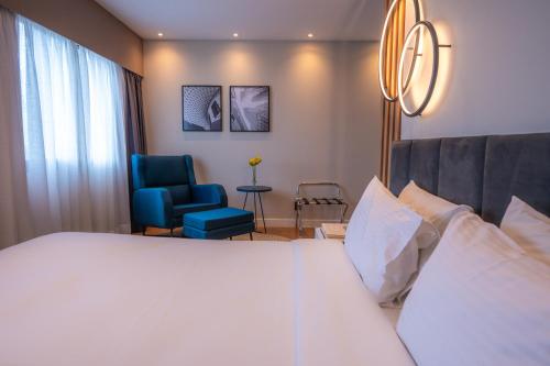 a hotel room with a bed and a blue chair at eSu&iacute;tes Congonhas by Atlantica in Sao Paulo