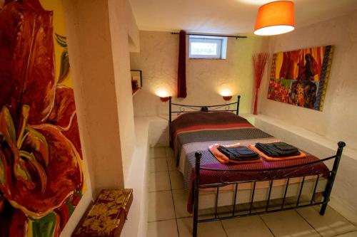 une petite chambre avec un lit dans une pièce dans l'établissement La Bastide de Mauragne - Gîte Les Pivoines, à Apt