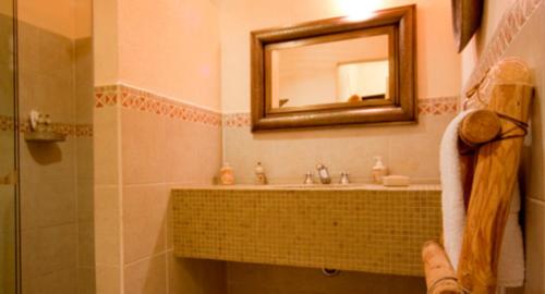 a bathroom with a sink and a mirror at El Chante Spa Hotel in Jocotepec