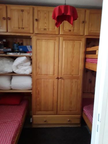 Cette petite chambre comprend des armoires et des lits en bois. dans l'établissement Appartement Reallon 5 personnes en rez de jardin, à Réallon
