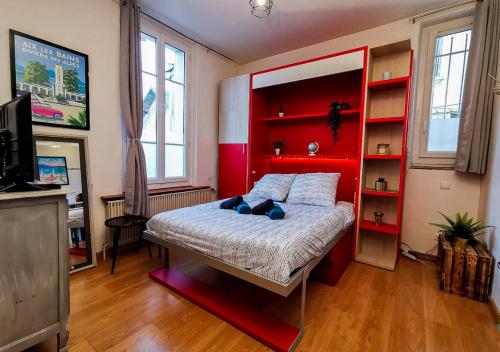 - une chambre avec un lit doté d'une tête de lit rouge dans l'établissement Le Nid Douill'Aix Netflix Wifi Centre-ville, à Aix-les-Bains