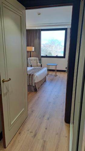 a room with a bed and a table and a window at Hotel Bahía in Santander