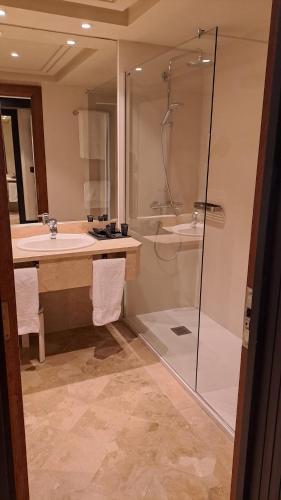 a bathroom with a shower and a sink and a tub at Hotel Bahía in Santander