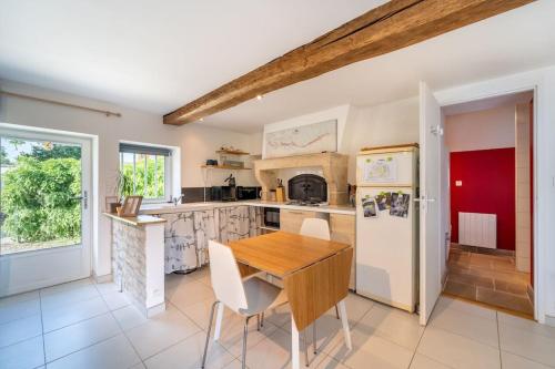 une cuisine avec une table en bois et un réfrigérateur dans l'établissement Le Petit Sondebois, à Saint-Gervais-en-Vallière