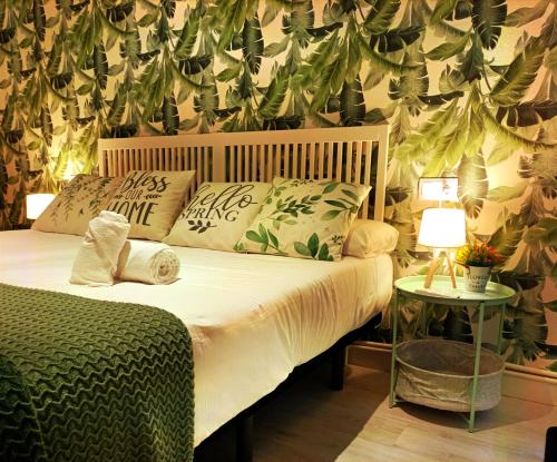 a bedroom with a bed with plants on the wall at JARAUTARESORT in Pamplona