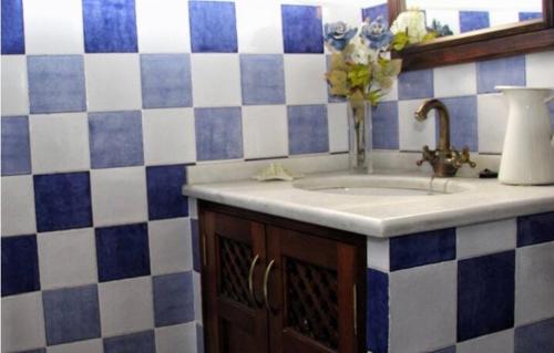 un bagno con lavandino e vaso di fiori di Cortijo el Lebrillo, Casa las Nieves. a El Burgo