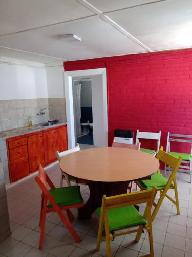 a table and chairs in a kitchen with a red wall at Depto amoblado in Gualeguaychú