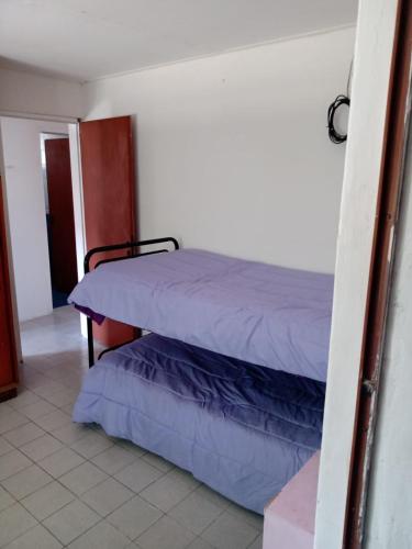 um quarto com uma cama com lençóis roxos em Depto amoblado em Gualeguaychú