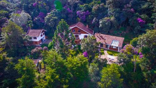 an aerial view of a house in the forest at Tília Pousada de Charme in Campos do Jordão