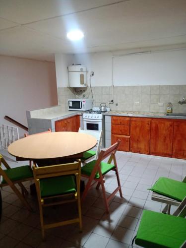 a kitchen with a table and some chairs and a table at Depto amoblado 3 habitaciones calle 3 de Caballería 463 in Gualeguaychú