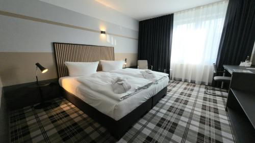 a hotel room with a bed with towels on it at Median Hotel Hannover Lehrte in Lehrte