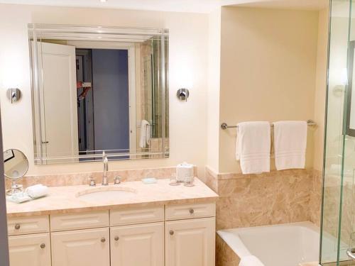 マイアミにあるFour Seasons Luxury Apartmentのバスルーム(シンク、鏡、シャワー付)