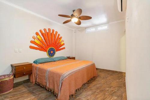 - une chambre avec un lit et un ventilateur de plafond dans l'établissement Tai Condo 2, à Barra de Navidad