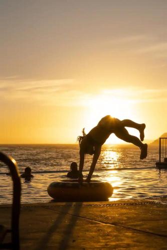 a man doing a trick on a surfboard on the beach at Tai Condo 2 in Barra de Navidad