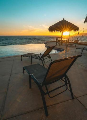 a group of chairs and an umbrella next to the ocean at Tai Condo 3 in Barra de Navidad