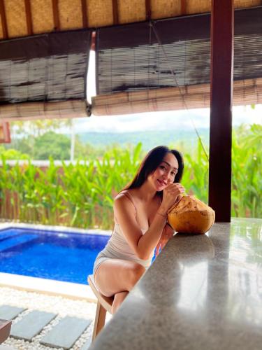 a woman sitting at a table with a loaf of bread at Bhumi Lovina Residence & Villa in Singaraja