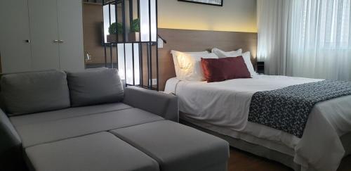 een hotelkamer met een bed en een bank bij 616A life (Batistela) · Studio Centro|Batel, moderno e bem equipado! in Curitiba