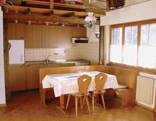 una cocina con mesa y 2 sillas alrededor en La Montagnette, VERCORIN, en Vercorin