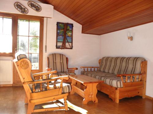 sala de estar con sofá, mesa y sillas en La Montagnette, VERCORIN, en Vercorin