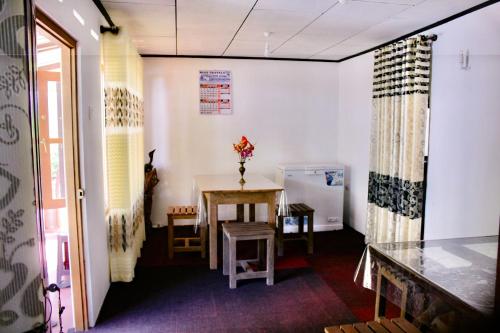 um pequeno quarto com uma mesa e um frigorífico em Sinharaja Pitadeniya Hut em Deniyaya