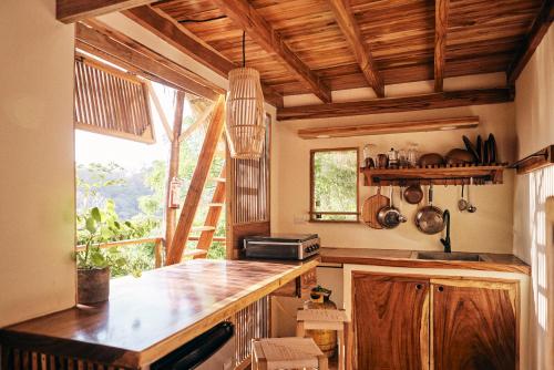 a kitchen with a wooden counter top and a window at Hostel Clandestino Maderas in Playa Maderas