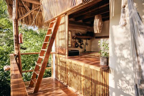 an outdoor kitchen with a ladder in a tiny house at Hostel Clandestino Maderas in Playa Maderas