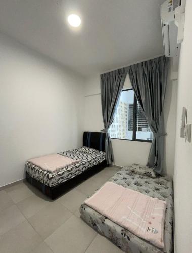 two beds in a room with a window at Happy House in Sandakan