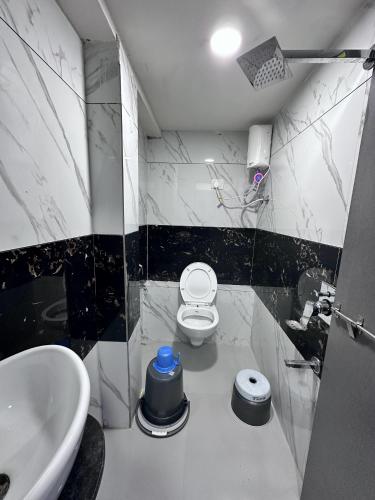 a bathroom with a white toilet and a sink at Hotel The Pacific in Ahmedabad
