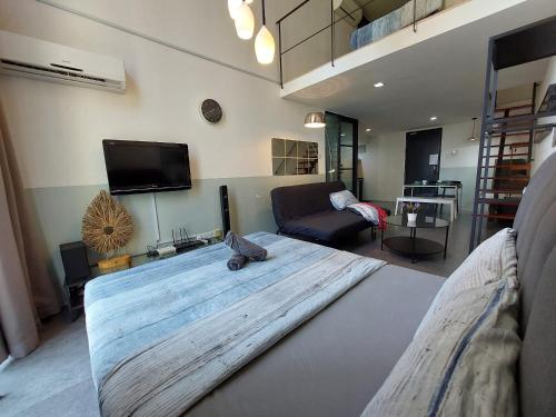 uma cama grande numa sala de estar com um sofá em Inspired Homes, Empire Duplex#1 em Petaling Jaya