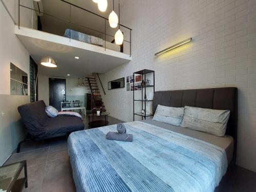 a bedroom with a large bed and a couch at Inspired Homes, Empire Duplex#1 in Petaling Jaya