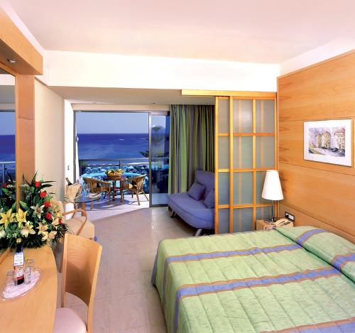 a hotel room with a bed and a living room at Calypso Beach in Faliraki