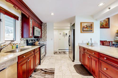 a kitchen with wooden cabinets and a stainless steel refrigerator at Penthouse Suite at Loon Landing in Lincoln