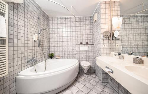 ein Badezimmer mit einer Badewanne, einem WC und einem Waschbecken in der Unterkunft Median Hotel Hannover Lehrte in Lehrte