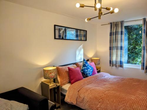 a bedroom with a bed and two lamps and a window at Small 1-Bed Apartment in London in Croydon