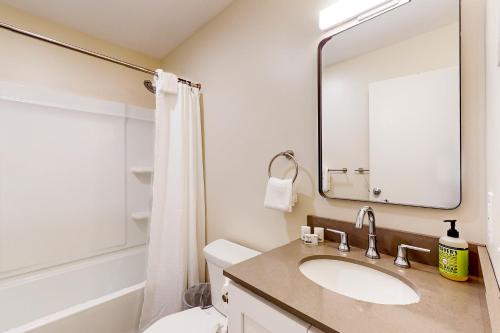 ein Badezimmer mit einem Waschbecken, einem WC und einem Spiegel in der Unterkunft Butternut Hill D4 in Waitsfield