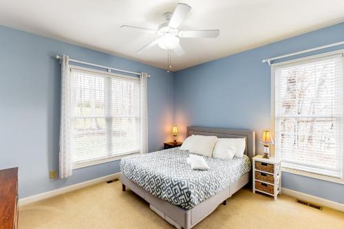 um quarto azul com uma cama e 2 janelas em Lake Daze em Mineral